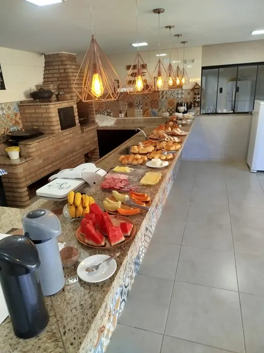 Mesa de café da manhã com frutas, pães e bolos caseiros